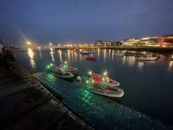 Four of the Dublin Boat Tour RIBs assembled alongside a pontoon in Dun Laoghaire Harbour with their navigation lights illuminated.