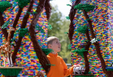 Child exploring colourful Lego built structures and animals in an outdoor display at Dublin Zoo