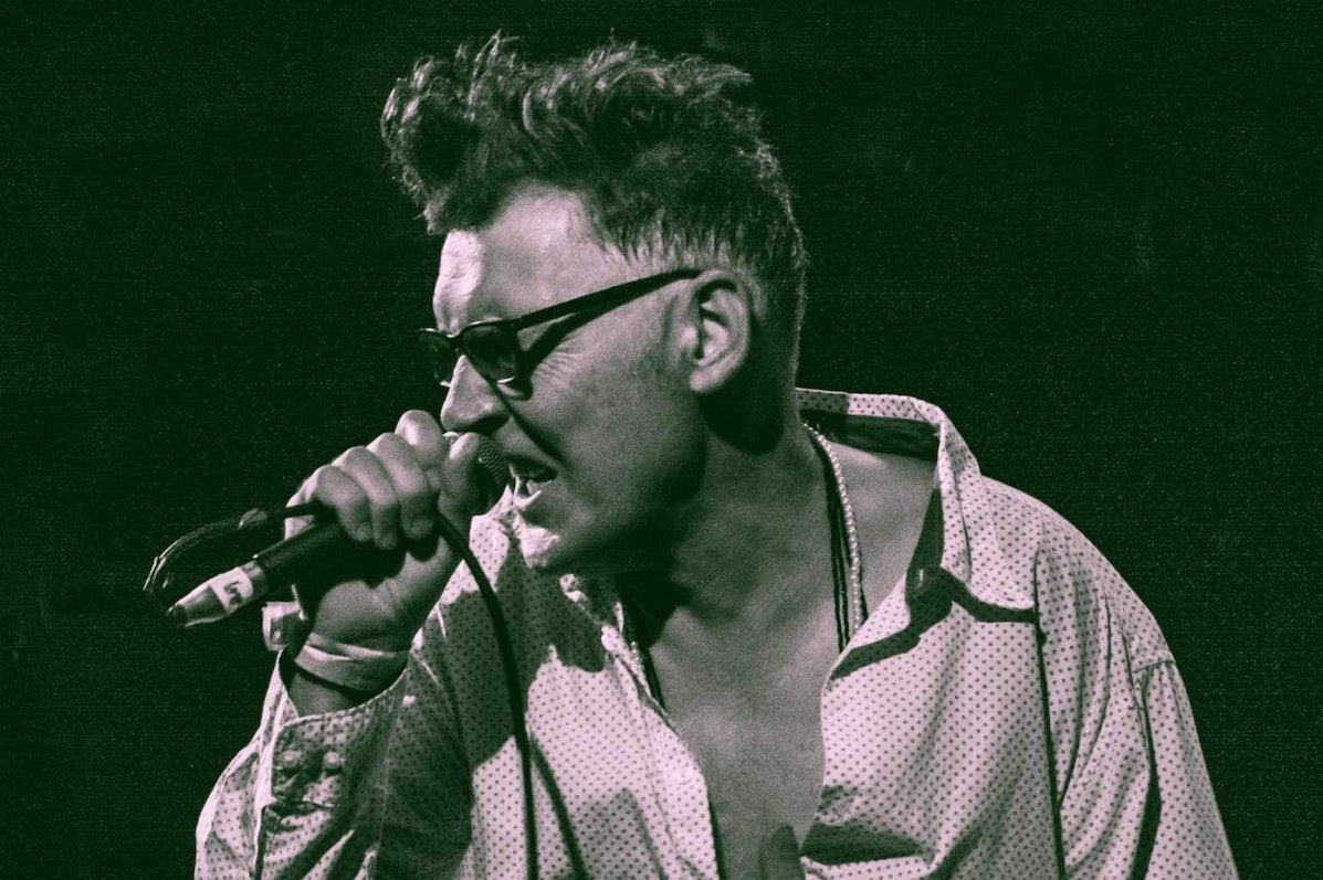 A man singing into a mic he's holding