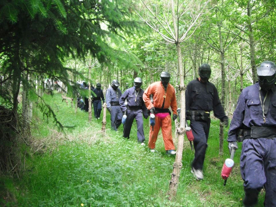 AWOL Outdoor Adventure people in paintball suits walking in the woods