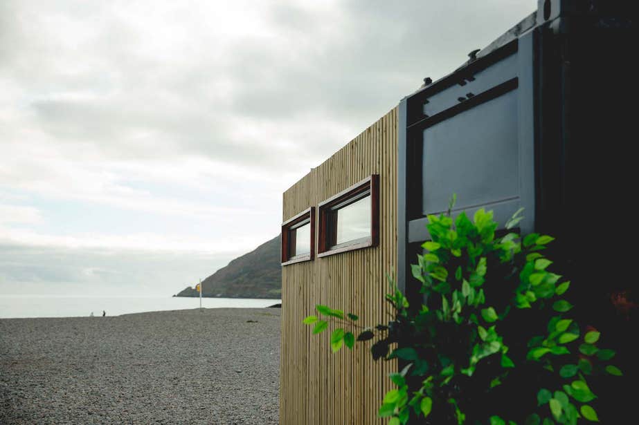 Fad Saoil Sauna on the beach in county Wicklow with a view of the water and expanse beyond.