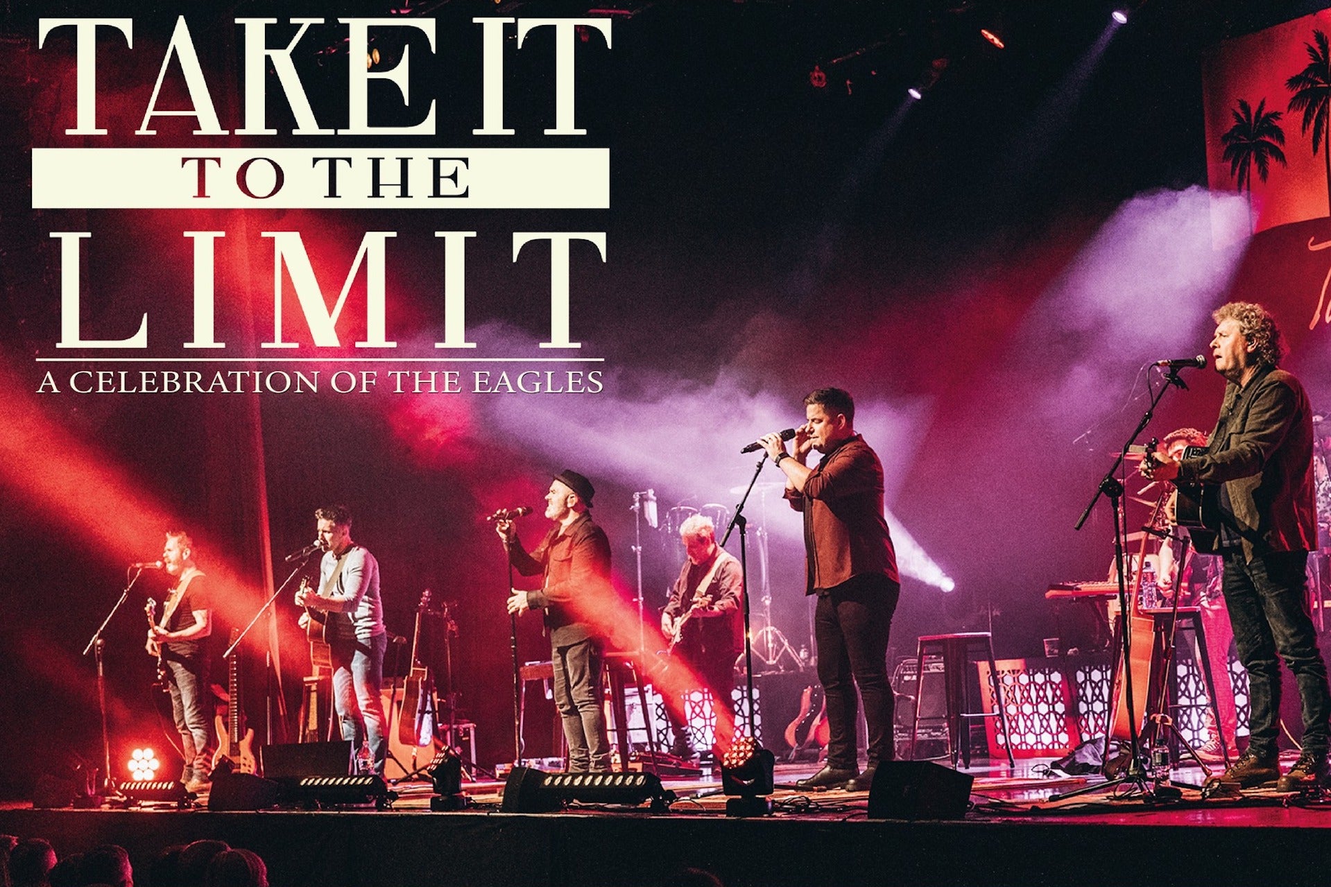 Red and purple lit stage with large group of musicians spread across the stage.