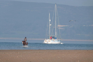 Image of horse rider and yacht in Lisfanon Beach
