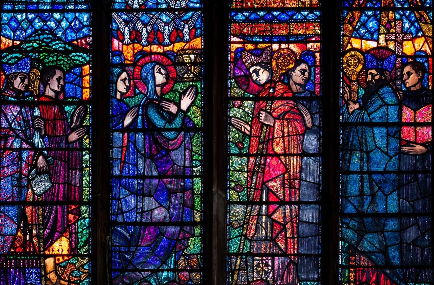 A stained glass window with colourful biblical scenes