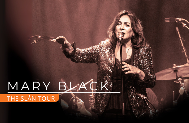 Mary Black The Slán Tour, a woman singing into a mic on a stand with right arm outstretched forward.