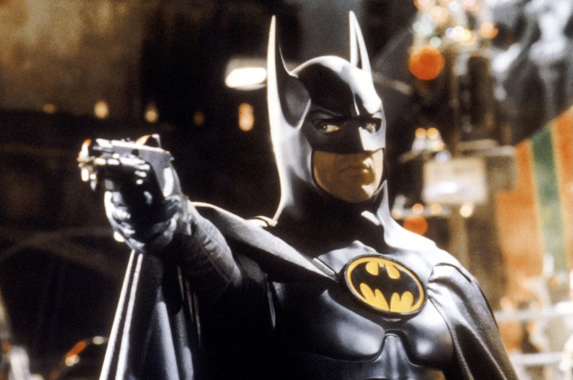 Batman pointing a firearm of some kind.