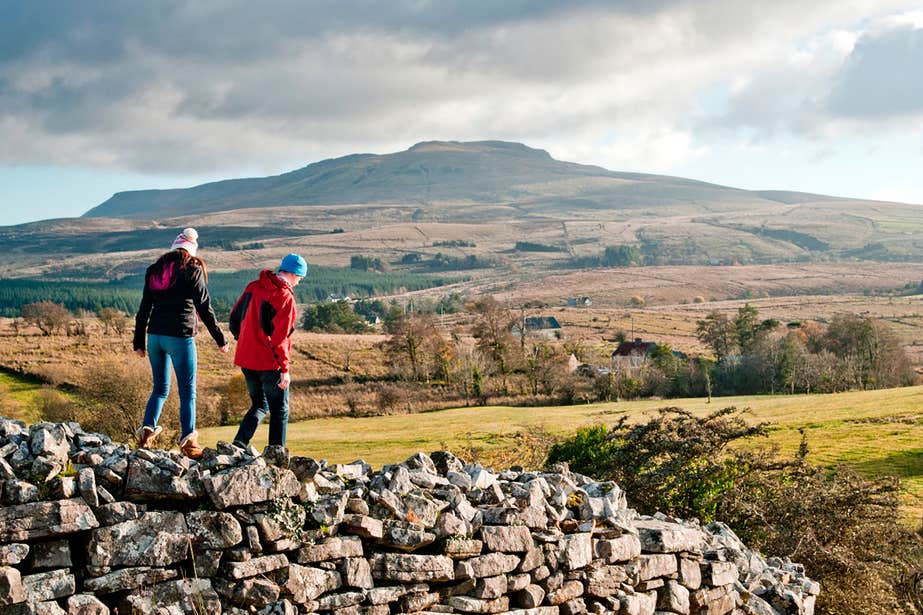 Two people walking on a stone wall in Cavan Burren Park, Cavan