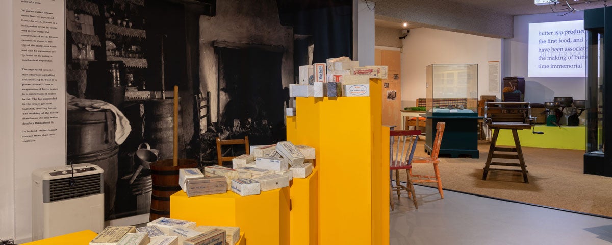 An exhibit in the Cork Butter Museum featuring displays of packaged butter alongside old equipment used in the production process