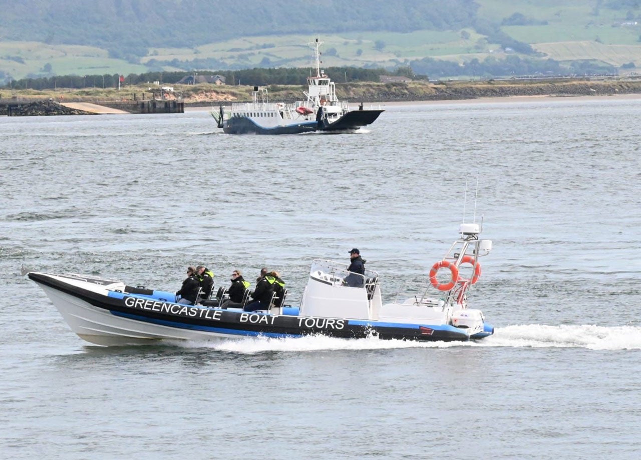 Greencastle Boat Tours out on tour with the ferry and the pier in the back ground