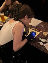 A guest leans in with full concentration, tattoo machine lit up and buzzing on practice skin. The perfect mix of focus, fun, and adrenaline at Dublin’s alternative art night.