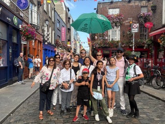 A group of people posing for the camera on a small city street