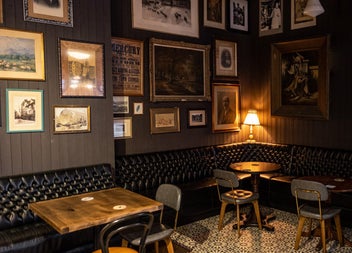 Dimly lit corner of a pub with tables and seating