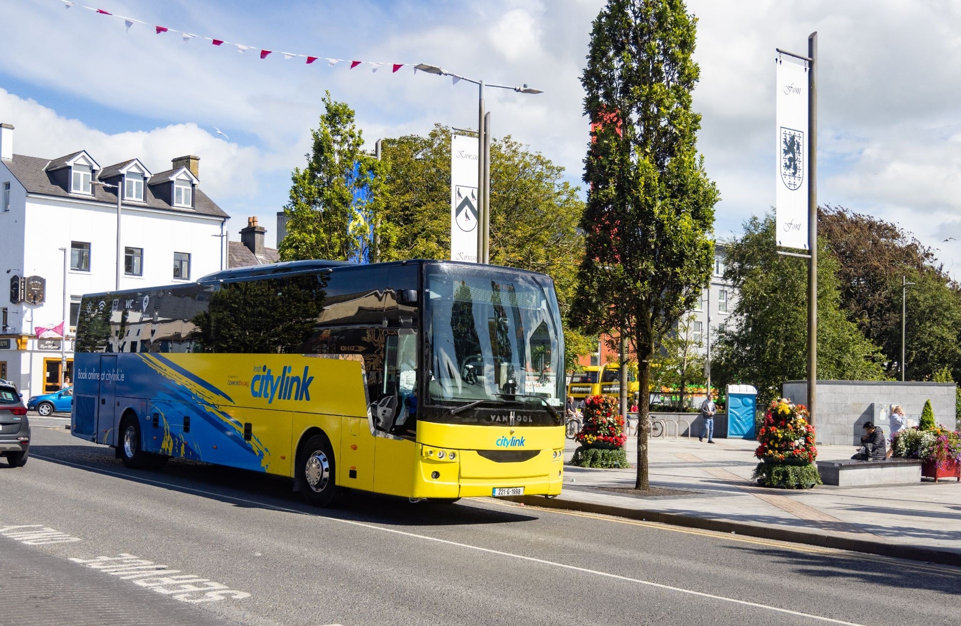 A blue and yellow coloured bus on a city street