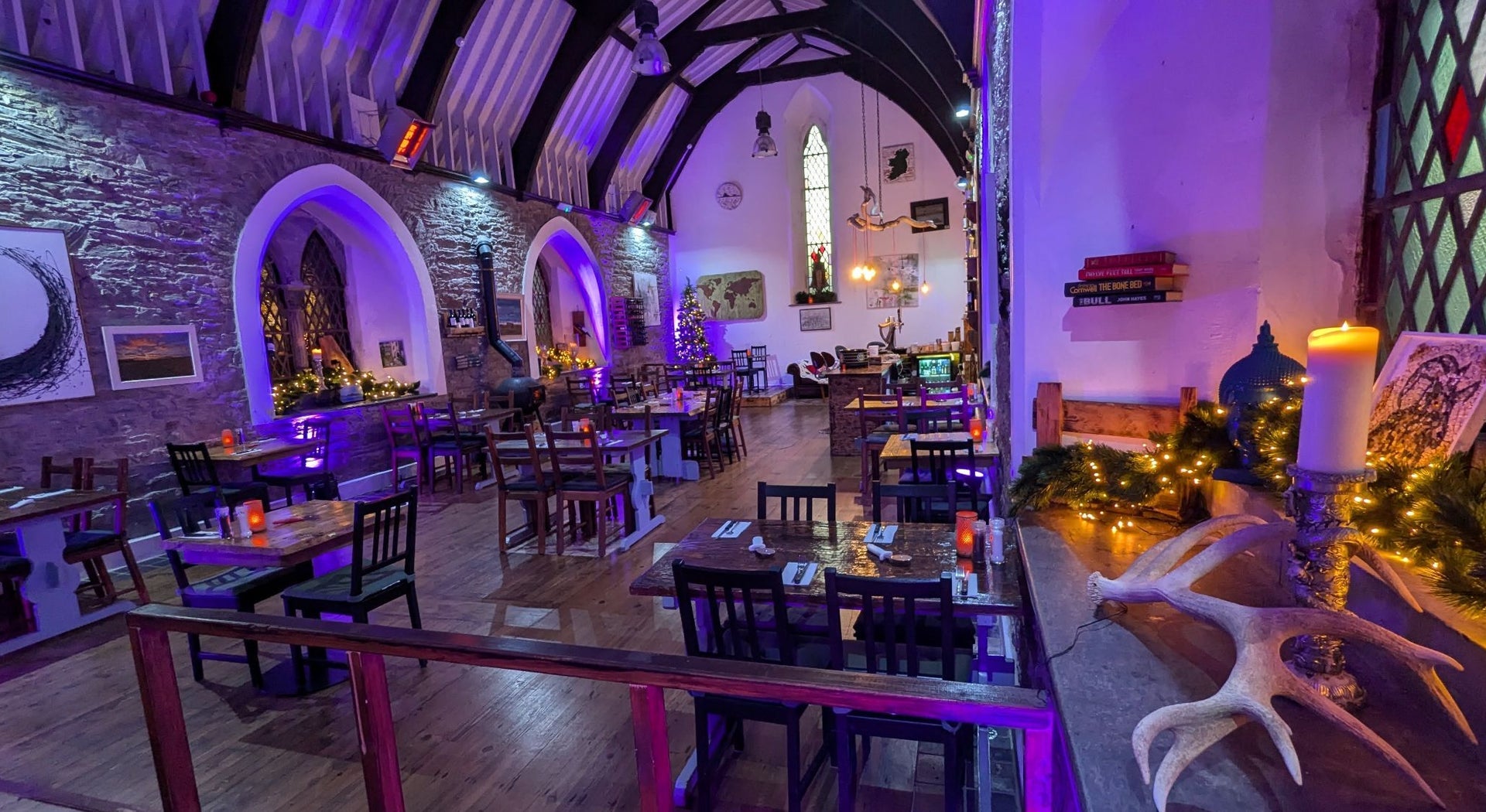 Interior of a converted church now a restaurant and lit by a purple hue