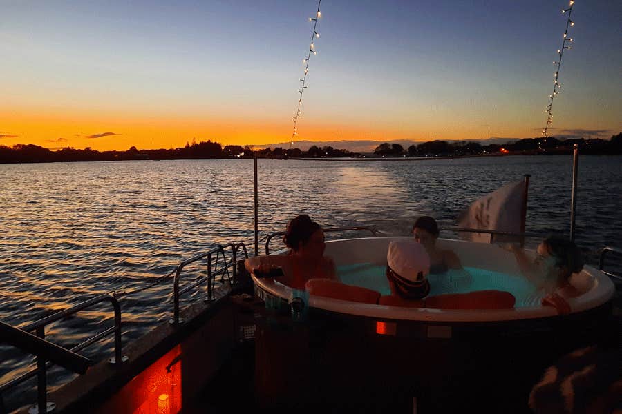 A group of friends enjoying a hot tub on The Hot Tub Boat