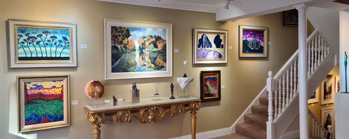 Image of six paintings on a wall and stairs on the right hand side