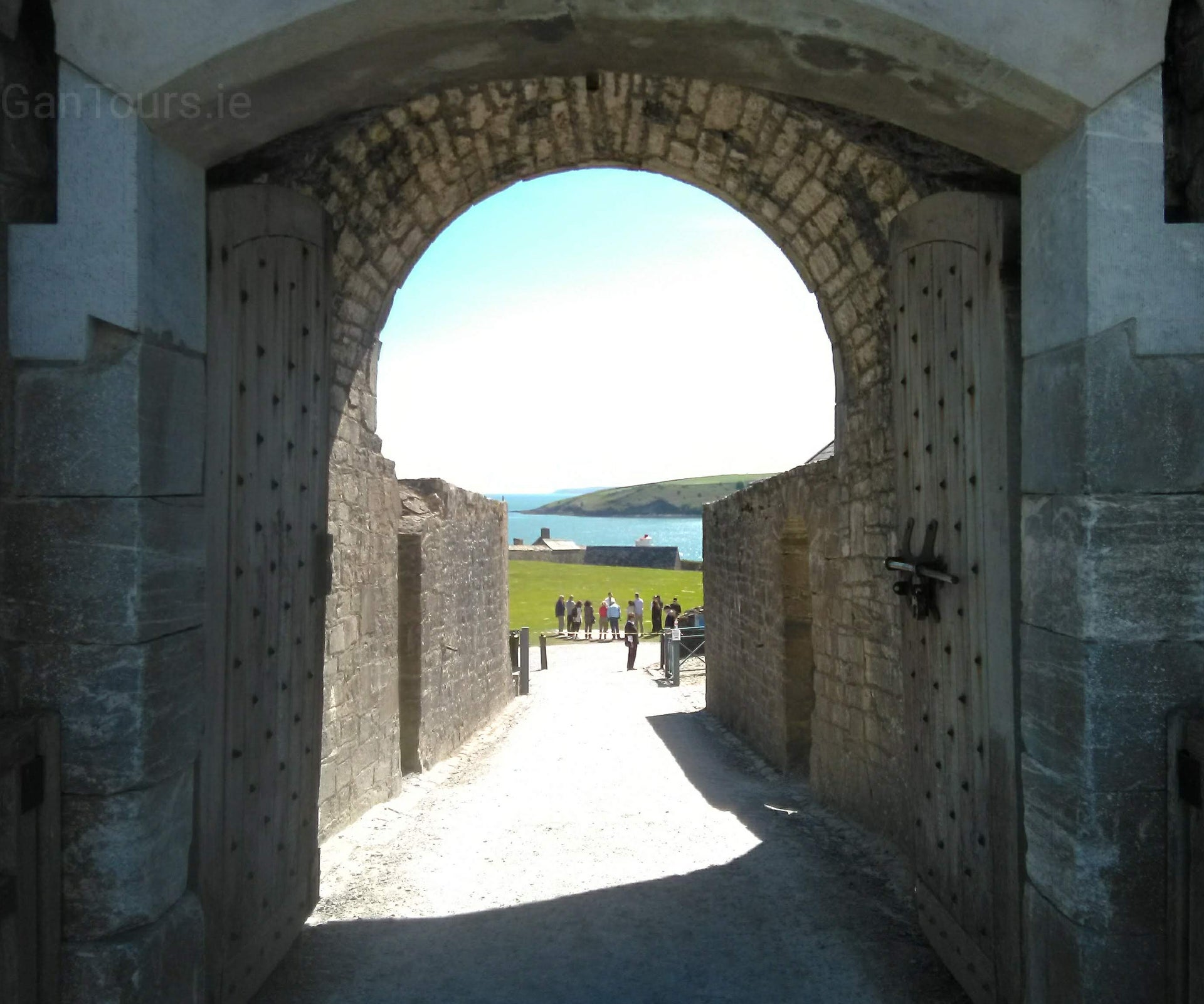 Cork West Transfers and Tours view of a tour group through a stone archway
