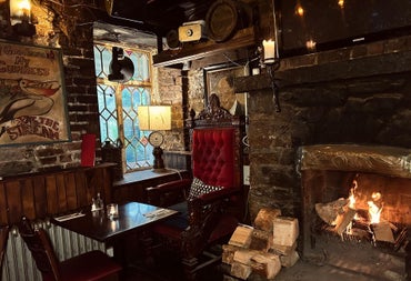 Interior of a pub with brick walls and old style décor beside a fire place