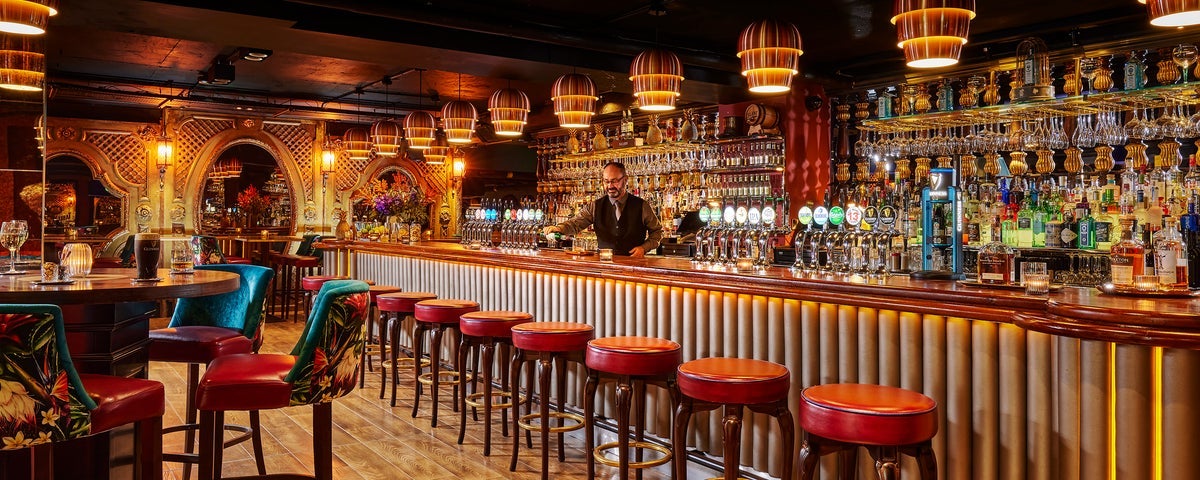 Barman pouring a drink at the bar in Bartleys