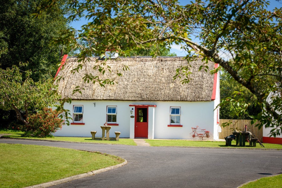 View of white cottage with red door
