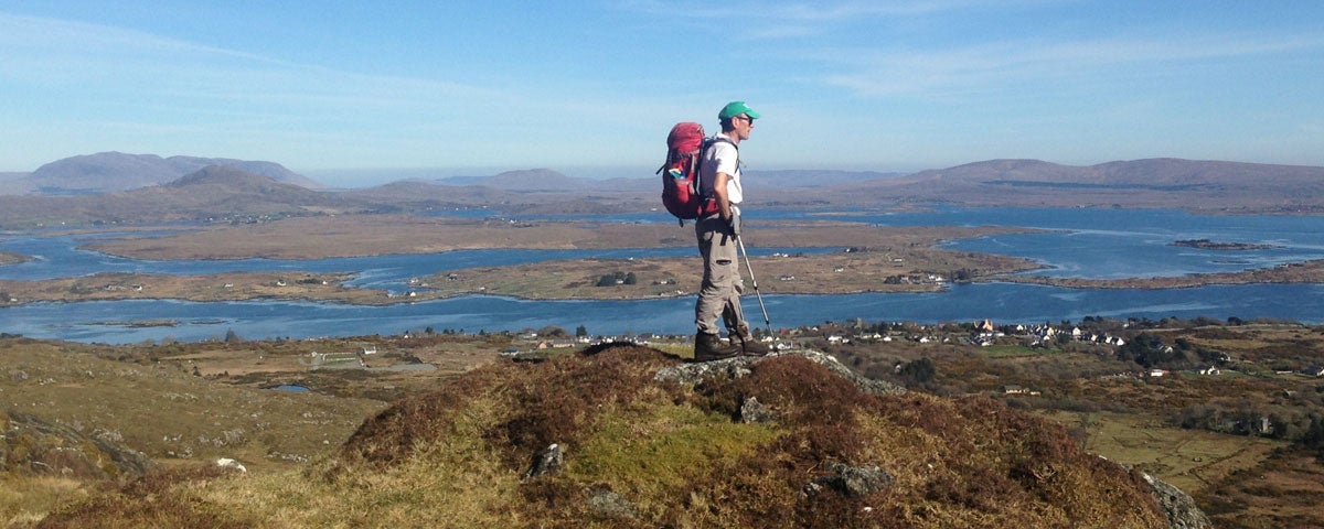 A man looking out over the sea from a hilltop view point