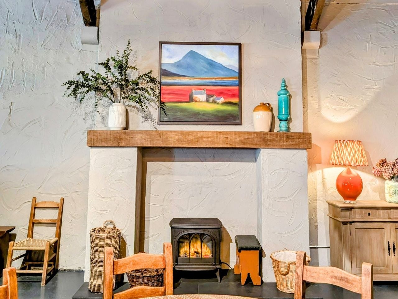 A small stove surrounded by old style wooden furniture in a restaurant