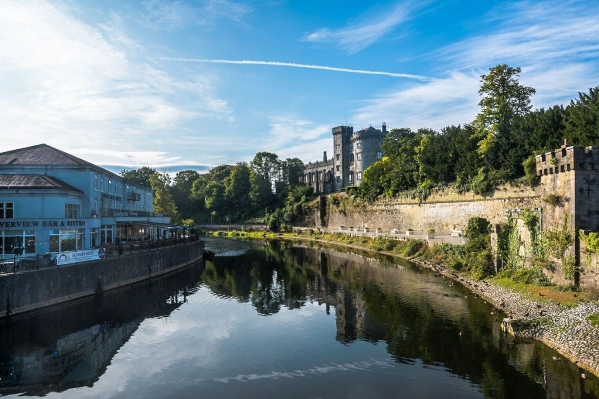 The exterior of a building with a terrace overlooking a river