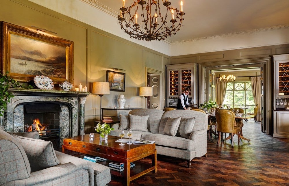 Grand living area in Ballynahinch Castle County Galway, with elegant furniture and large fireplace.
