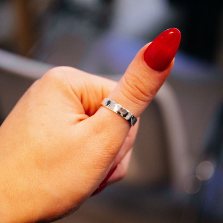 Silver ring on red nail varnished thumb at Silverworks