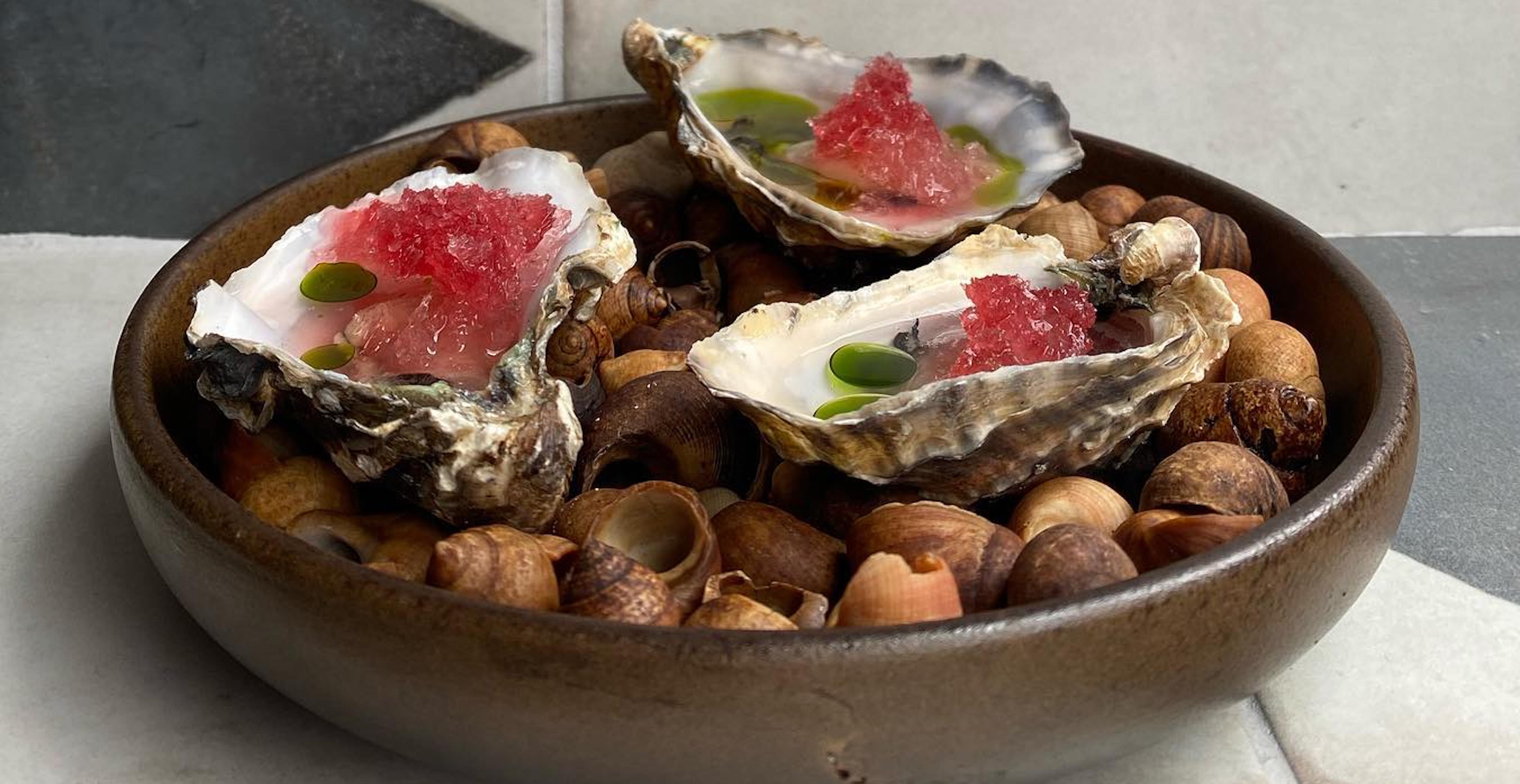 Oysters served on a dish of seashells. 