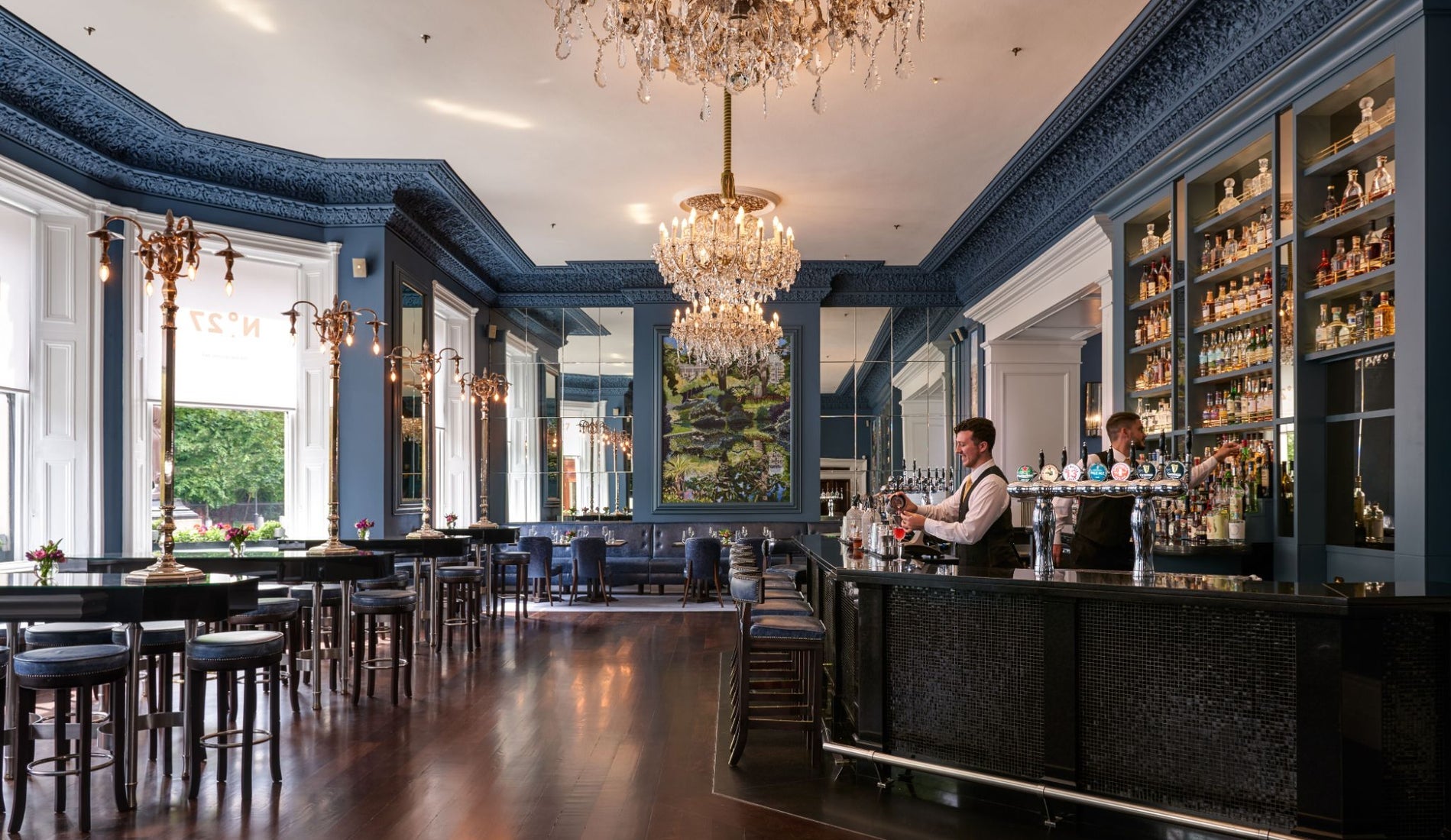 Elegant bar and lounge interior with chandeliers, mirrored walls and a well stocked bar