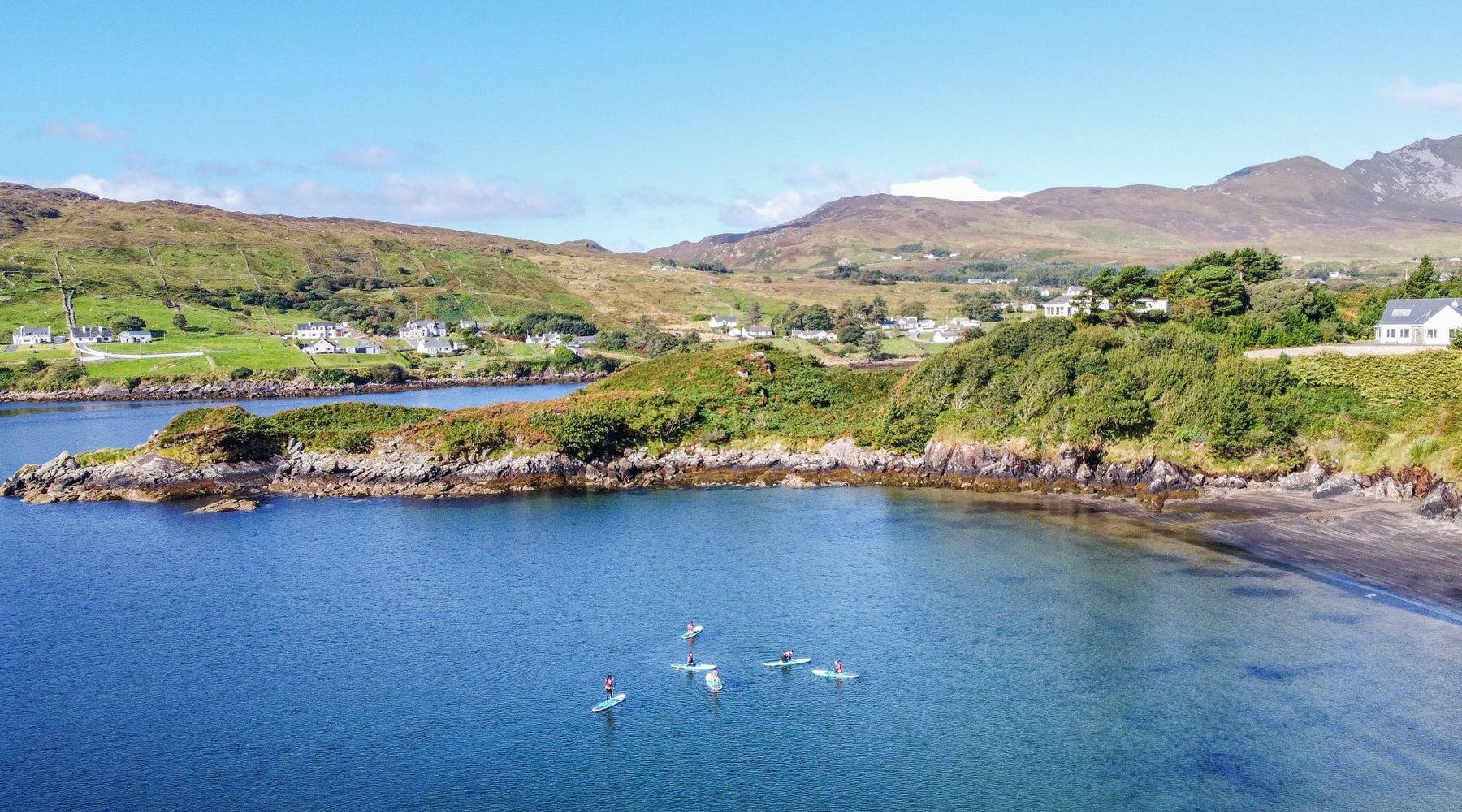 Aerial view of a group of stand up paddle boarders in a small harbour