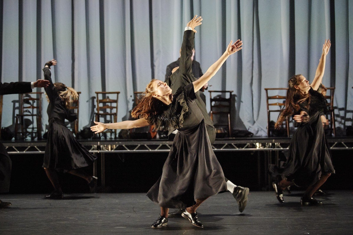 MÁM, Teac Damsa, O'Reilly Theatre, DTF 2019. People in long, dark clothes are dancing on a stage with arms outstretched.