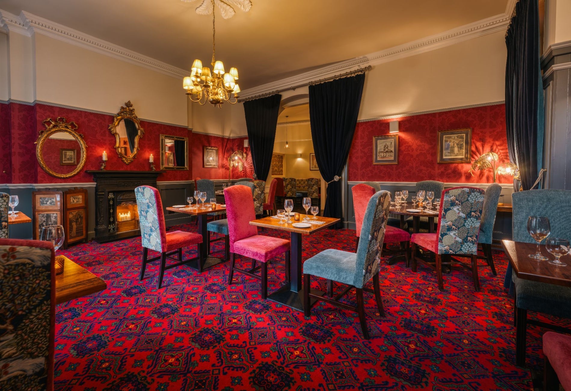 Elegant restaurant dining room with Georgian décor ornate mirrors patterned carpet and warmly lit tables