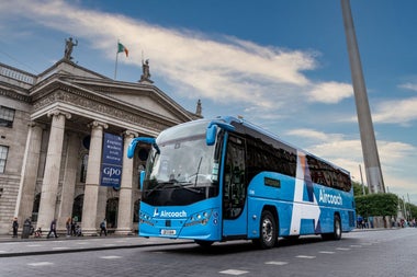 An Aircoach bus on a busy city street
