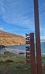 View of a brown road sign at Keem Bay on Achill Island with Wander Éire Tours
