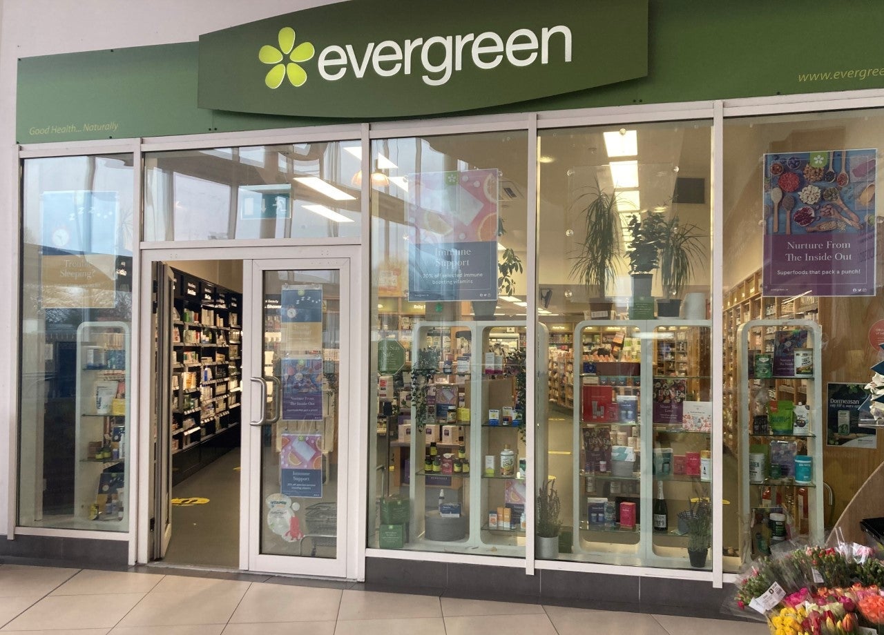 A shop exterior with floor to ceiling glass windows and lots of products on display