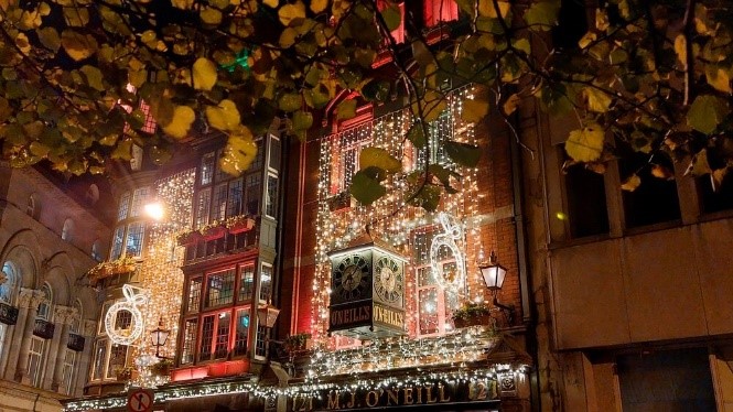 Festive Dublin lights illuminate historic buildings, creating a magical contrast between vibrant holiday displays and the city’s rich architectural heritage.