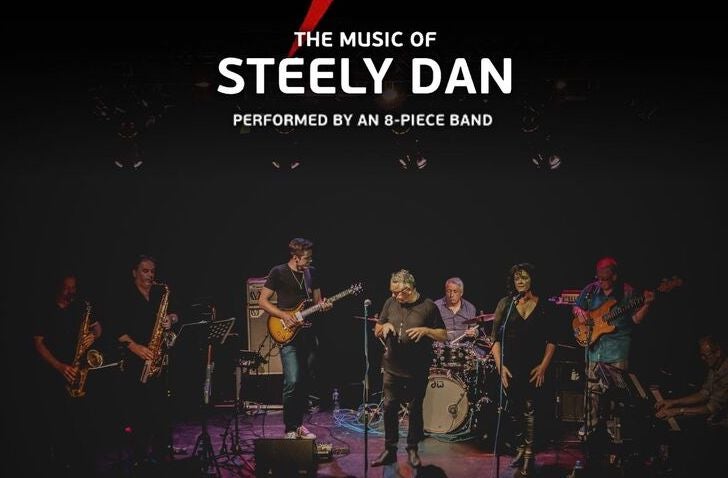 AJA - The Music of Steely Dan. Musicians playing on a darkly lit stage.
