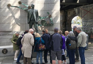 A tour group standing at a statue of James Connolly with a tour guide