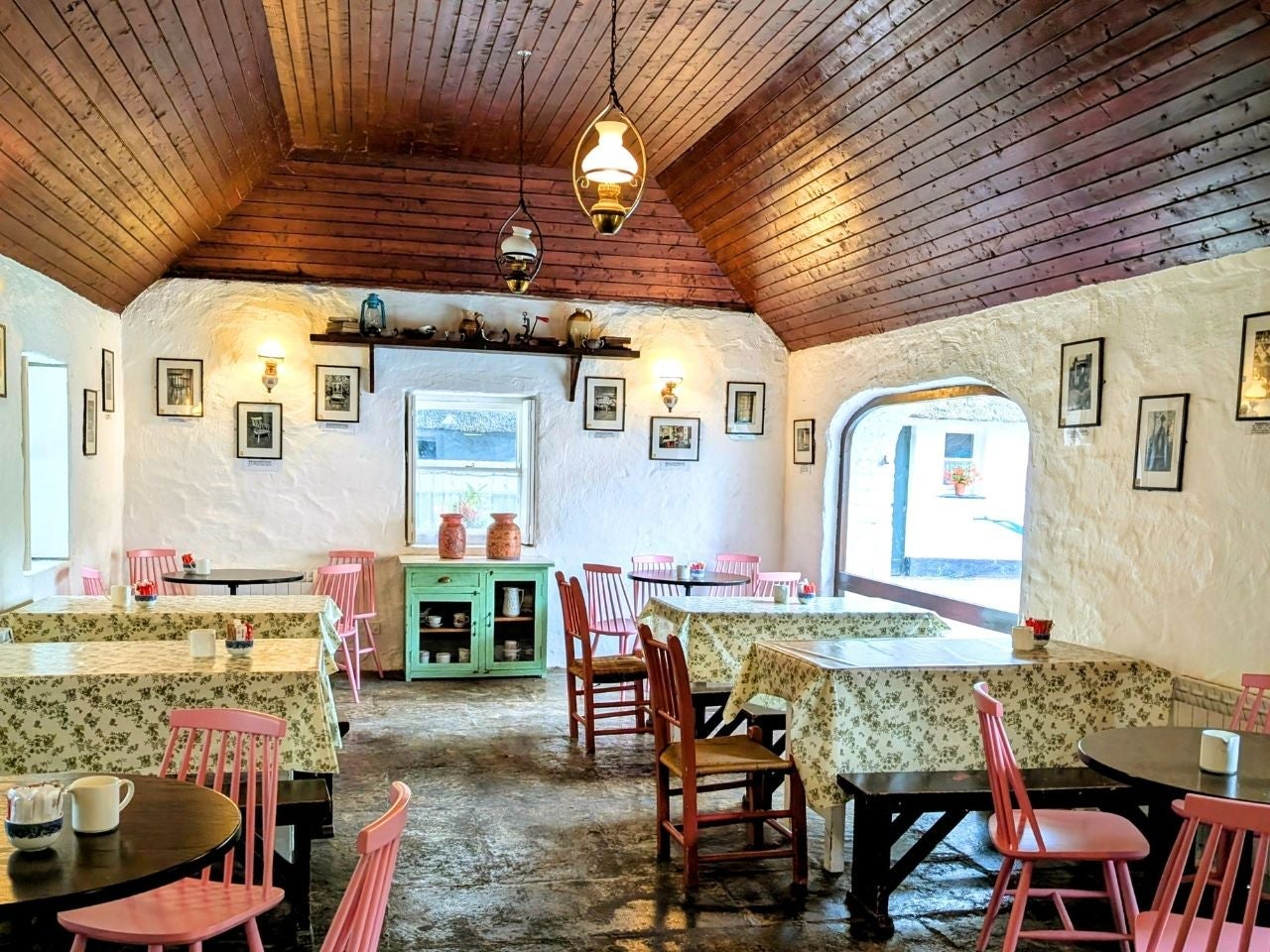 Rustic tea room interior with floral tablecloths and pastel chairs around small tables