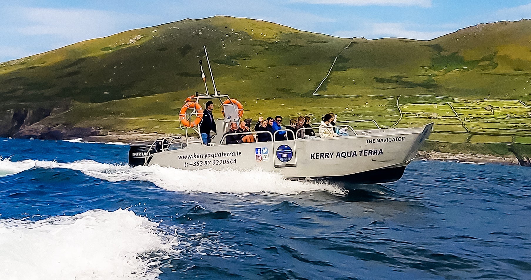 A speed boat with a group on board circle the island from the sea