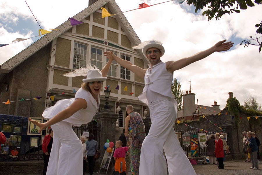 Two performers on stilts outside Birr Theatre during an Arts event