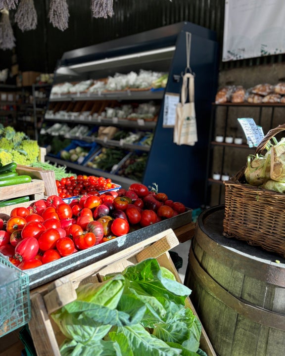 Tomatoes and green vegetables on display in a Farm Shop