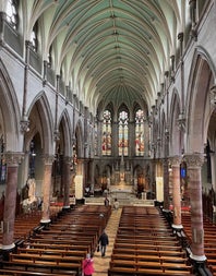 The interior of a church with a high vaulted ceiling and stained glass windows