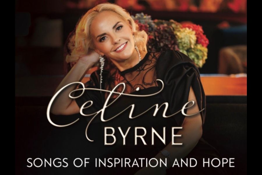 Celine Byrne - Songs of Inspiration & Hope - a smiling woman in black dress, leaning on her right raised hand.