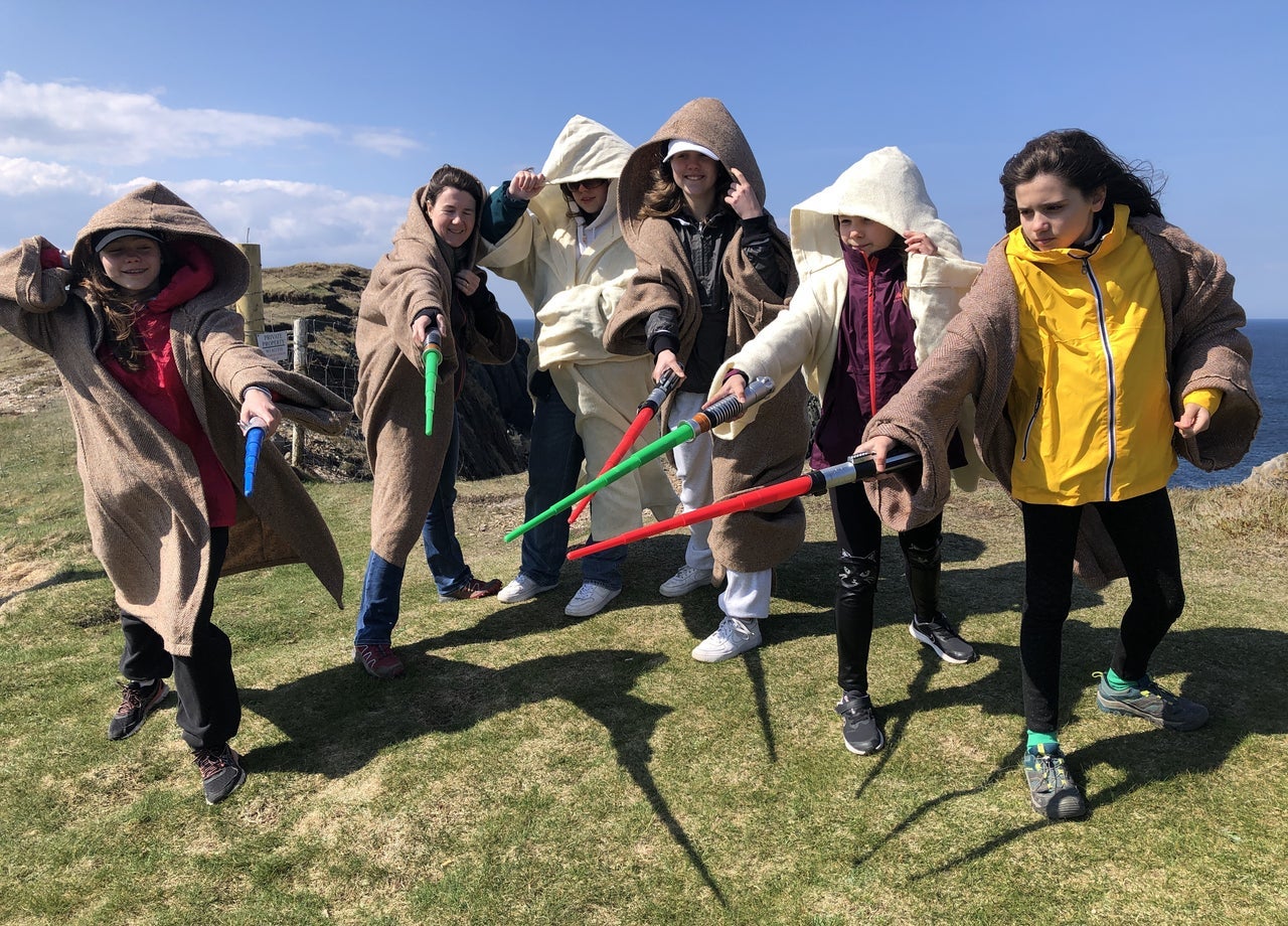 A family group in Star Wars costumes posed with light sabres