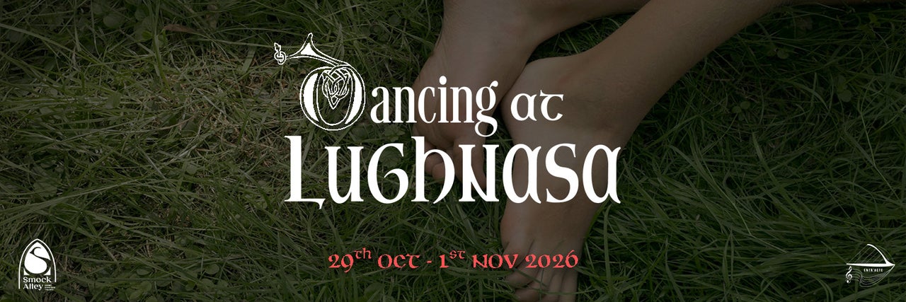 Feet in the grass with the title of the play in white writing