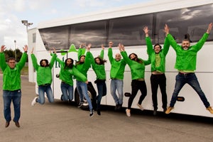 Tour group jumping in front of bus
