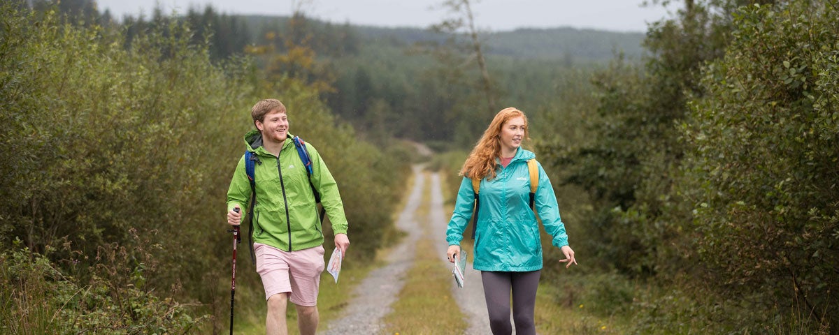 A man and a woman walking along a country road